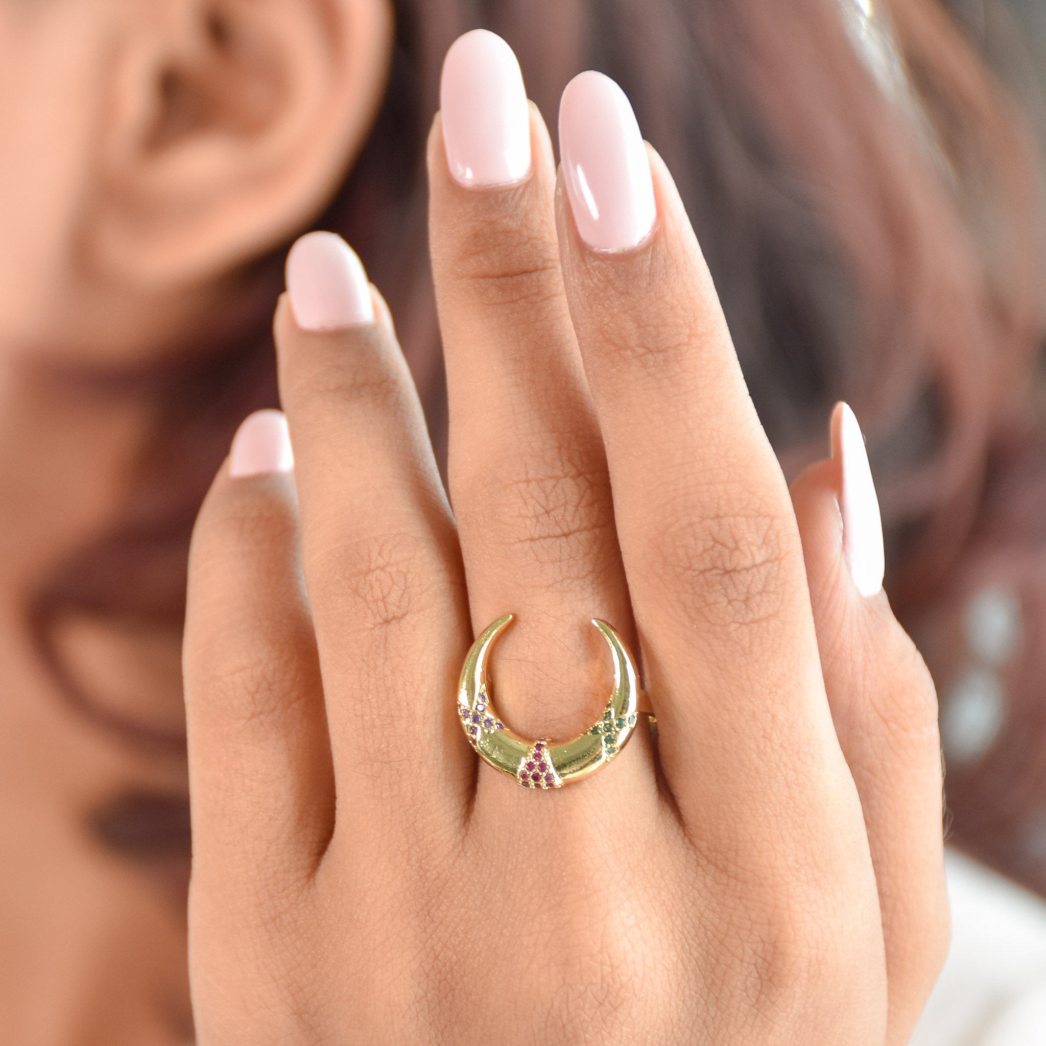 A stacked set of three adjustable gold-toned rings featuring a tiger head motif, a woven infinity band, and a fluid horseshoe-shaped ring.
