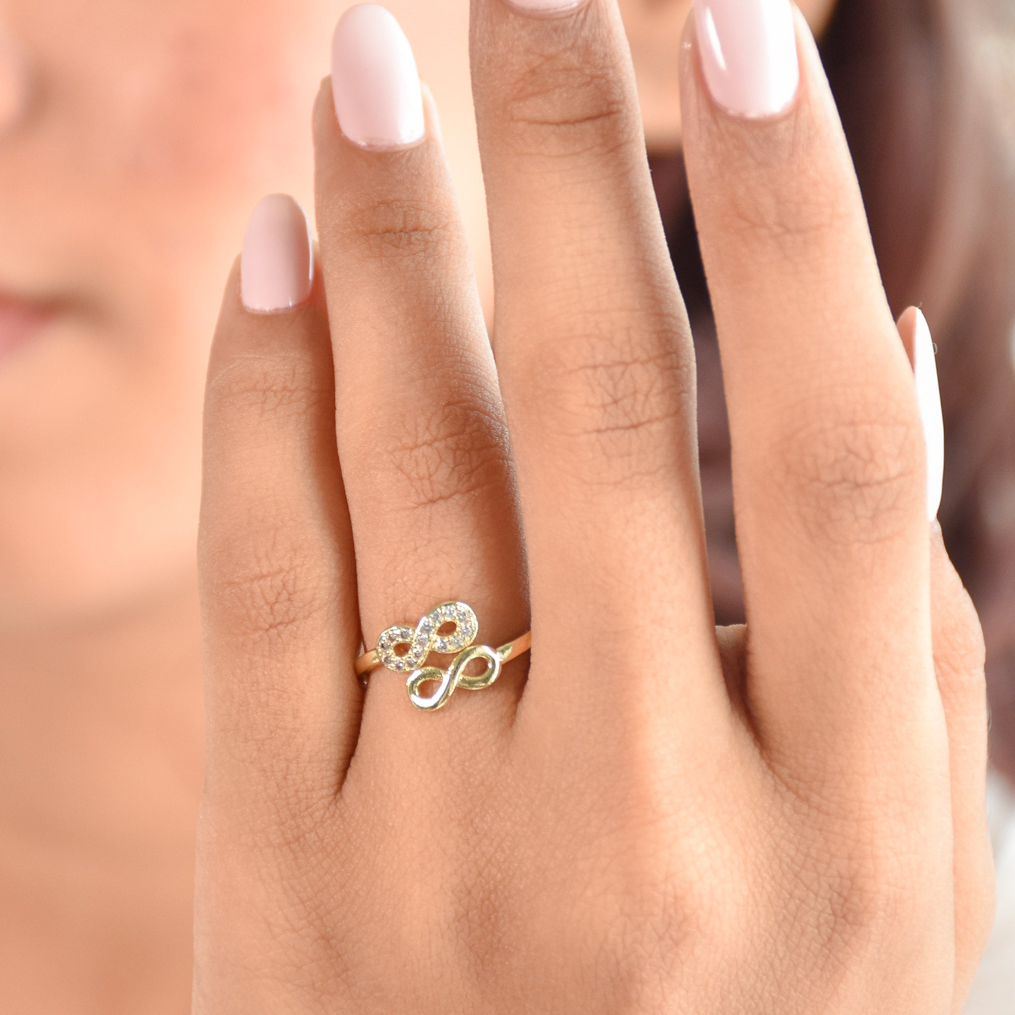 A stacked set of three adjustable gold-toned rings featuring a tiger head motif, a woven infinity band, and a fluid horseshoe-shaped ring.