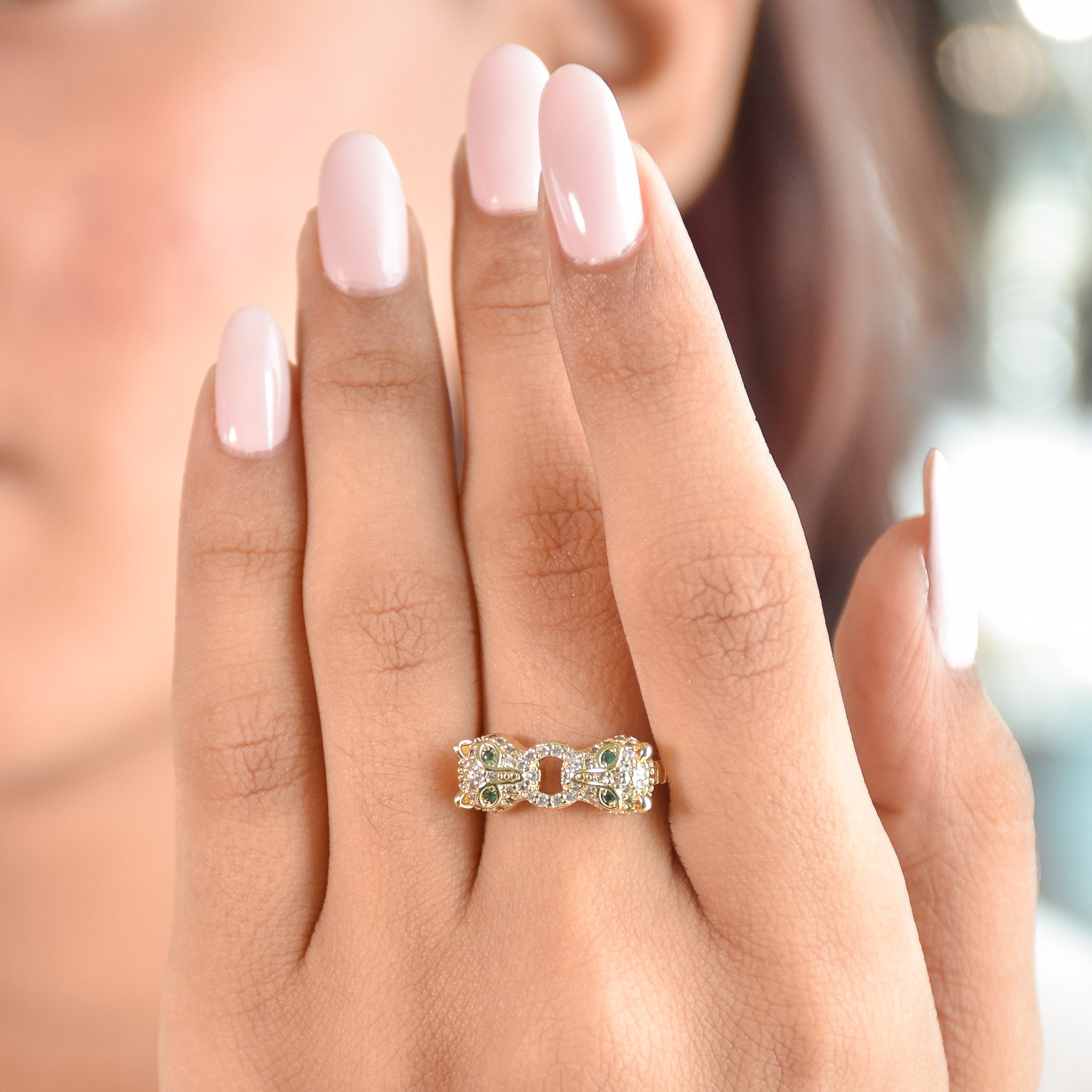 A stacked set of three adjustable gold-toned rings featuring a tiger head motif, a woven infinity band, and a fluid horseshoe-shaped ring.
