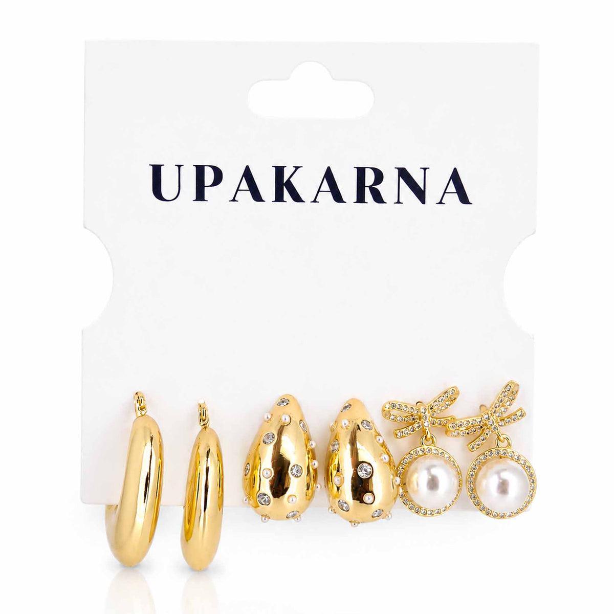 Gold-tone earring stack featuring polished hoop earrings, embellished teardrop earrings with crystal and pearl details, and pearl bow dangler earrings on a clean white background.