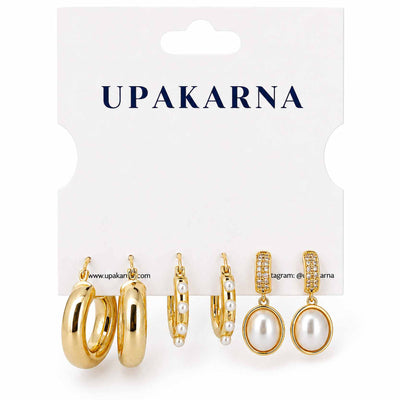 Gold-tone earring stack featuring chunky polished hoops, pearl-lined hoops, and pearl drop earrings with sparkling crystal detailing, displayed on a clean white background.