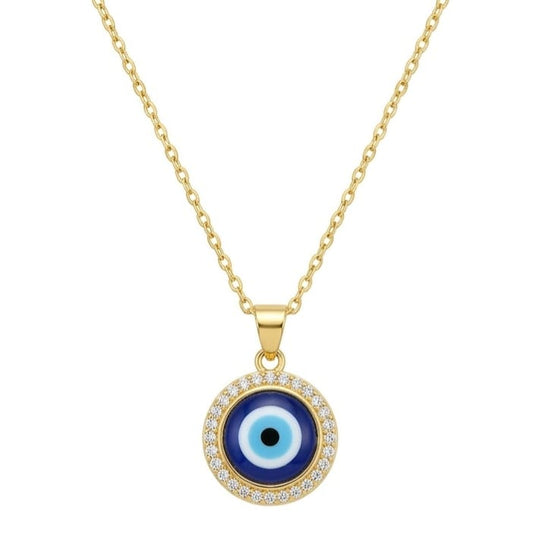 A gold necklace featuring a round Evil Eye pendant suspended on a fine gold chain. The pendant has a black center pupil, light blue inner ring, and dark navy outer ring, framed by a sparkling halo of clear stones. The jewelry is centered on a clean white square background with a dark gray frame.
