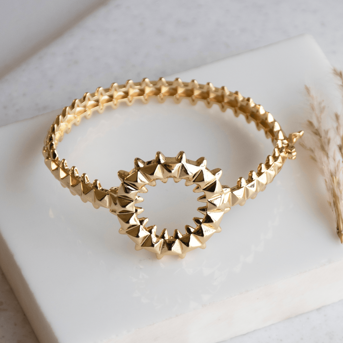 Bold golden spiked-design bangle with an anti-tarnish finish and openable clasp style, perfect for party wear, casual glam, and statement styling.

