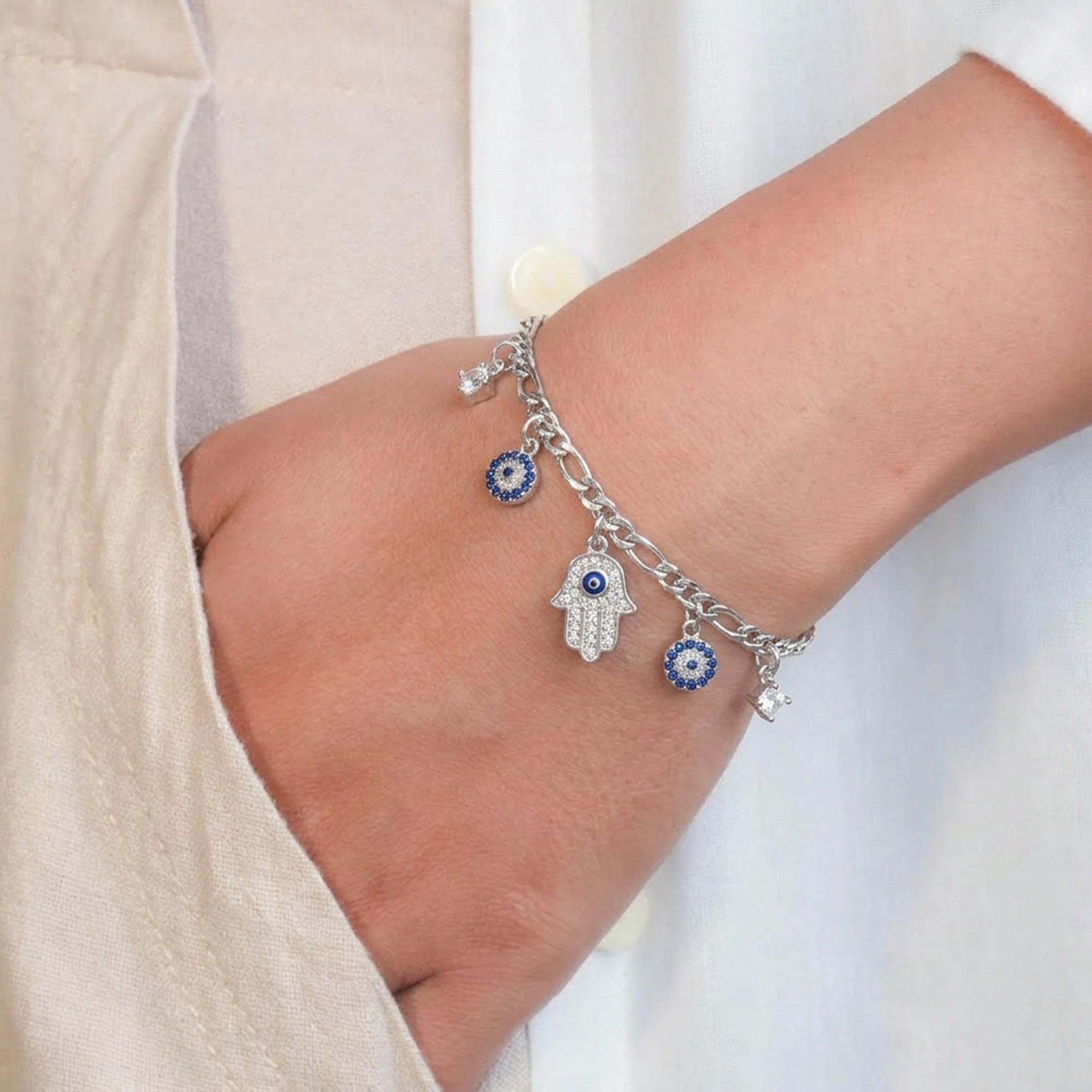 Hamsa Charm 925 Sterling Silver Bracelet featuring a stylish curb and link chain adorned with a sparkling Hamsa hand charm, blue evil eye accents, and crown charms