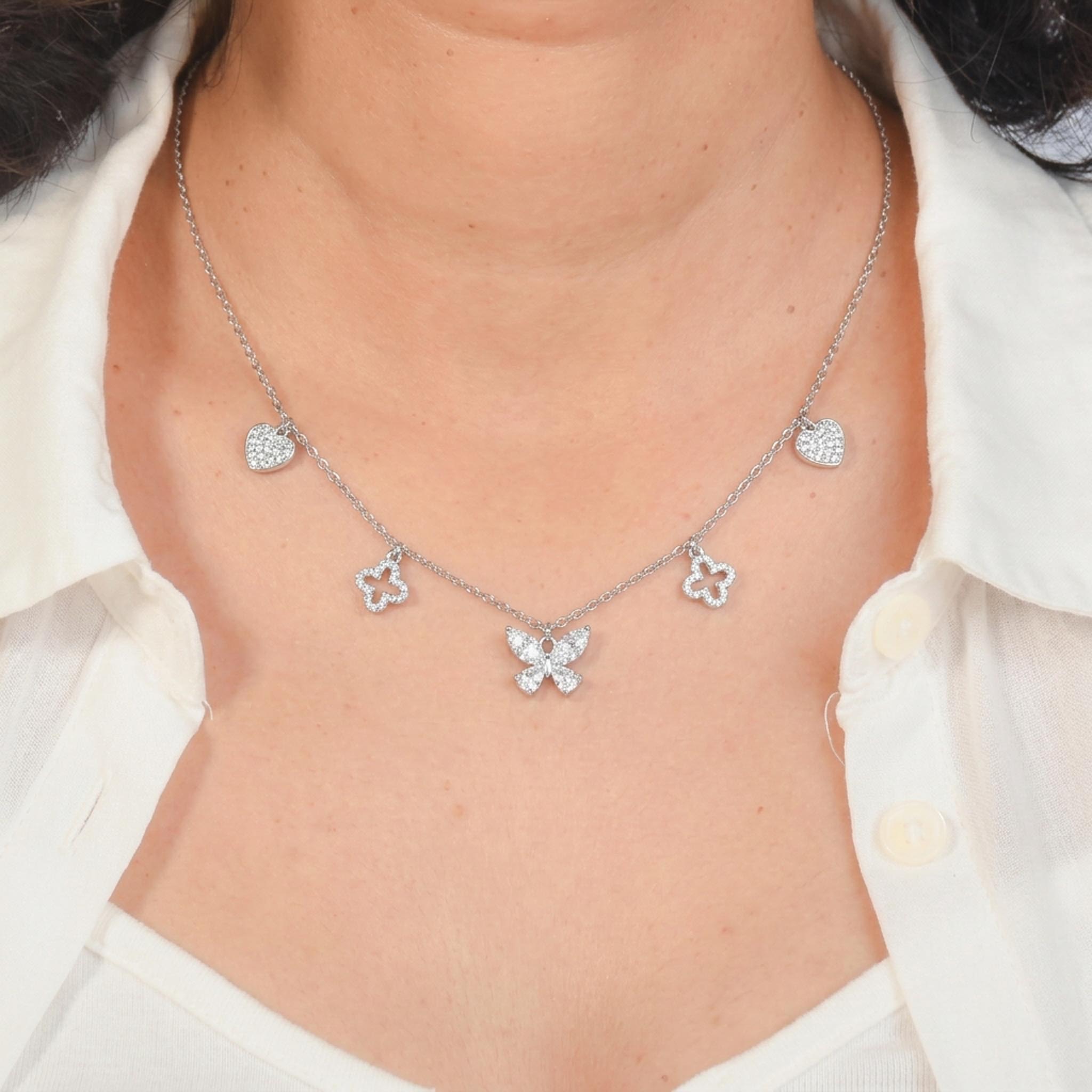 Butterfly Charm Necklace with Heart and Clover Accents in Silver Tone and Pav Crystal Detailing, Worn on a Model