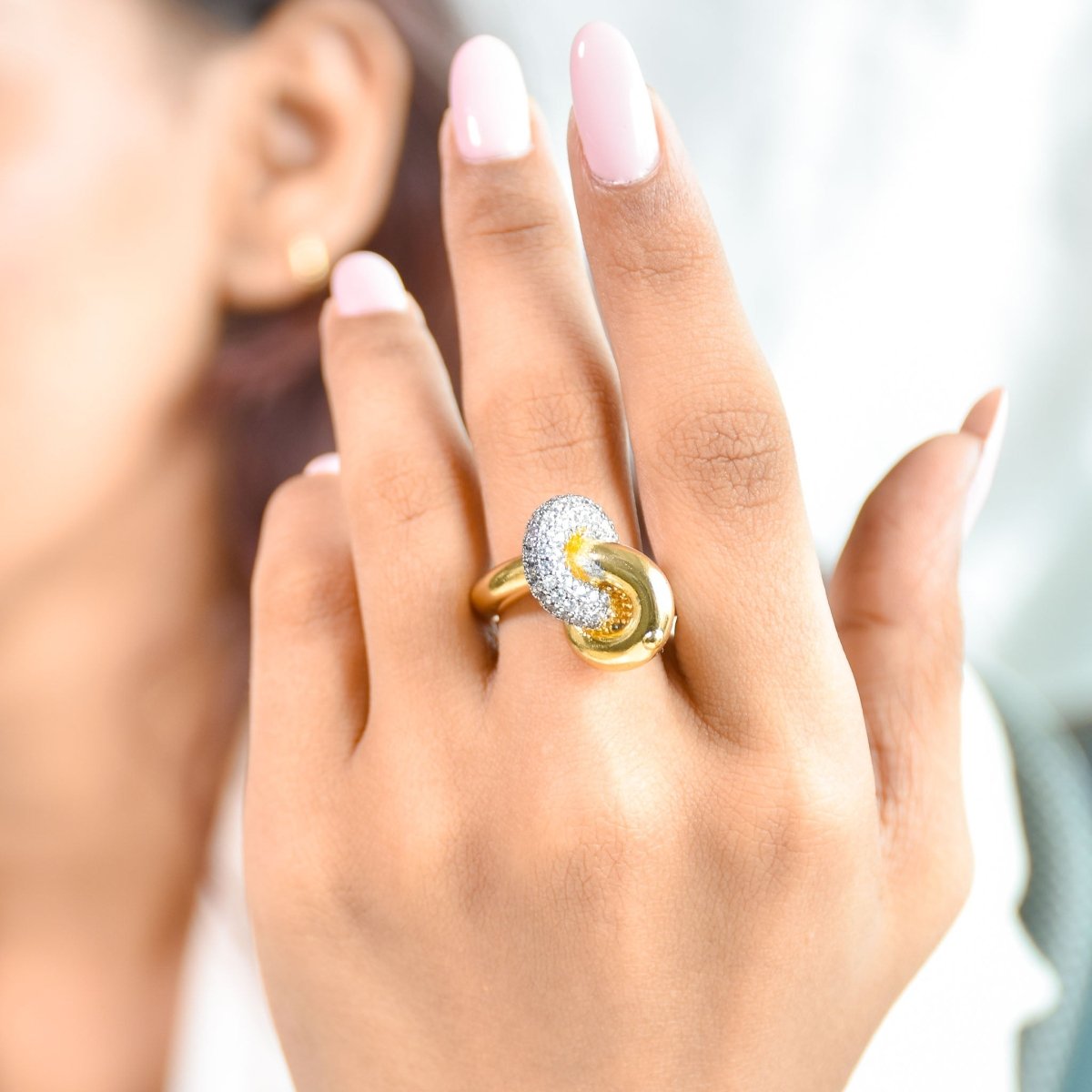 Elegant golden intertwined knot ring with sparkling pavé detailing and an anti-tarnish finish, perfect for everyday sophistication, romantic styling, and versatile wear.
