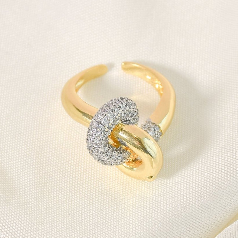 Elegant golden intertwined knot ring with sparkling pavé detailing and an anti-tarnish finish, perfect for everyday sophistication, romantic styling, and versatile wear.
