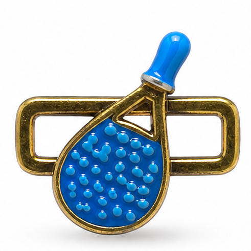 Detailed blue pickleball paddle jewellery charm featuring a glossy bright-blue paddle with a textured surface of raised blue dots, a matching blue handle with a silver accent ring, a gold metal outline around the paddle, and textured antique-gold rectangular loops extending horizontally from both sides.