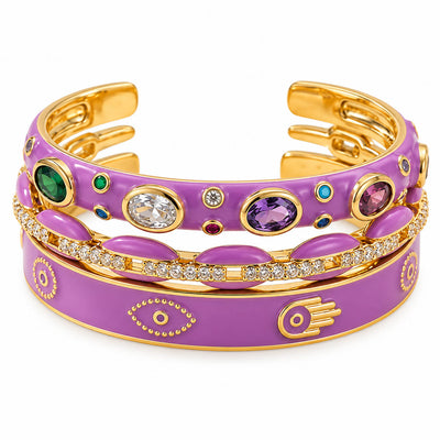 Three stacked purple and gold anti-tarnish bangles featuring vibrant enamel detailing, multicolored gemstone accents, sparkling crystal pavé, and Evil Eye motifs, creating a bold statement stack with a premium polished finish for everyday wear.