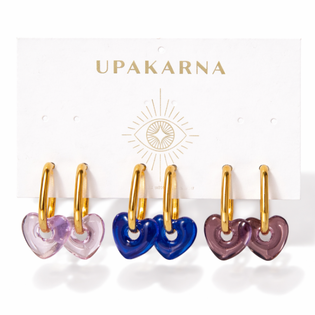 Upakarna Mini Heart Hoop Earring Stack featuring three gold hoops with lavender, blue, and brown heart charms.
