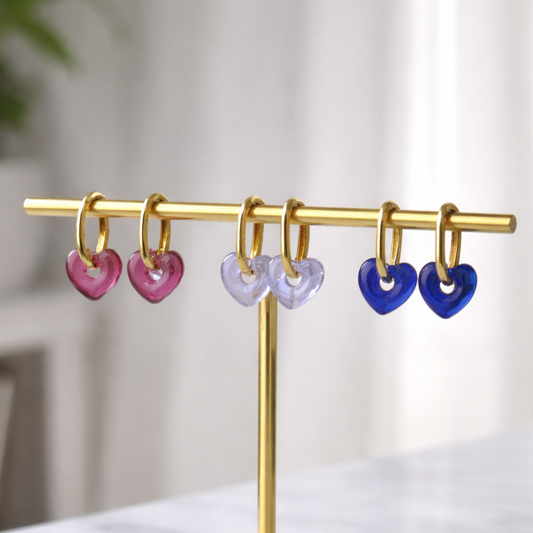 Upakarna Mini Heart Hoop Earring Stack featuring three gold hoops with lavender, blue, and brown heart charms.