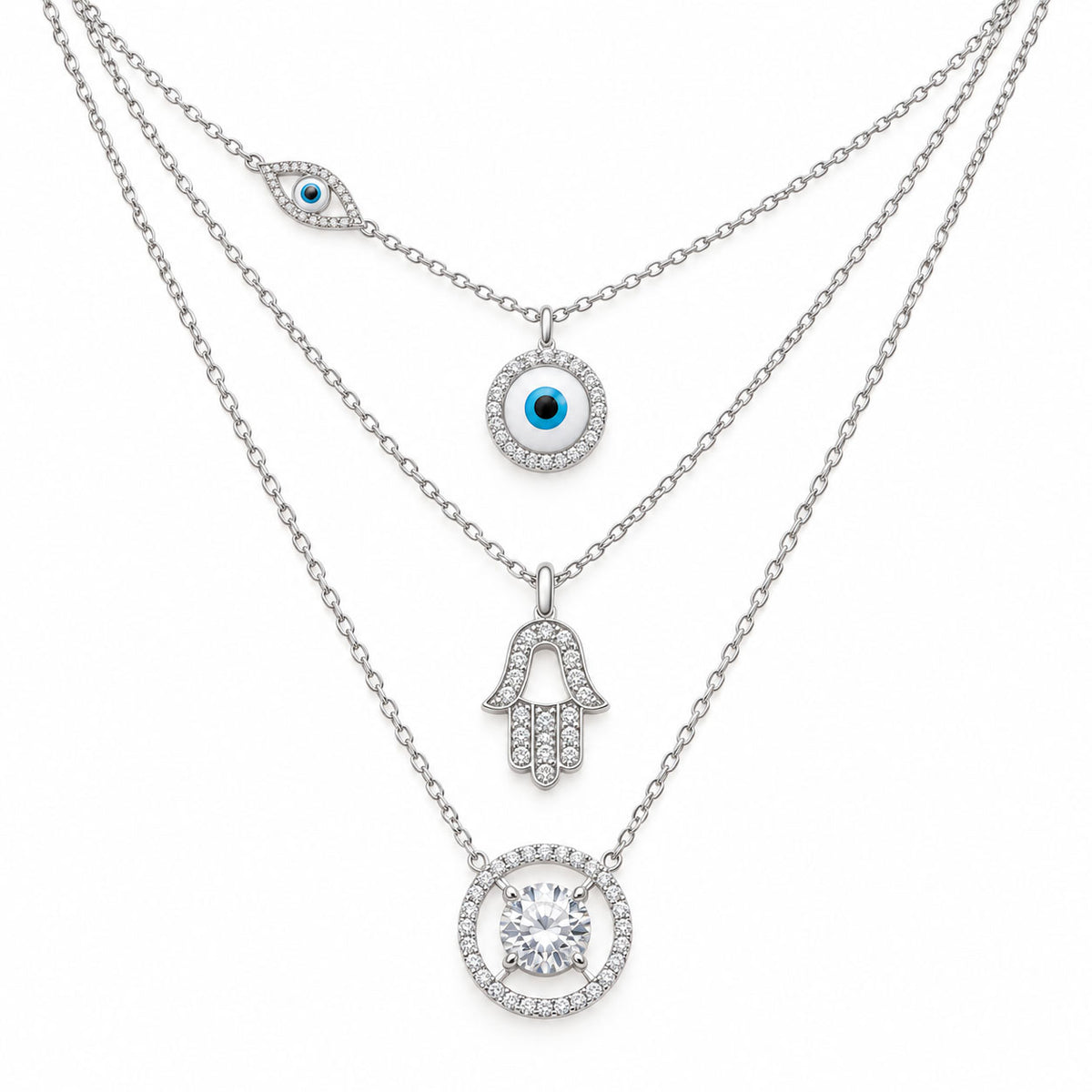Upakarna silver layered necklace set featuring an evil eye chain, crystal evil eye pendant, Hamsa hand pendant, and solitaire circle pendant on a clean white background.