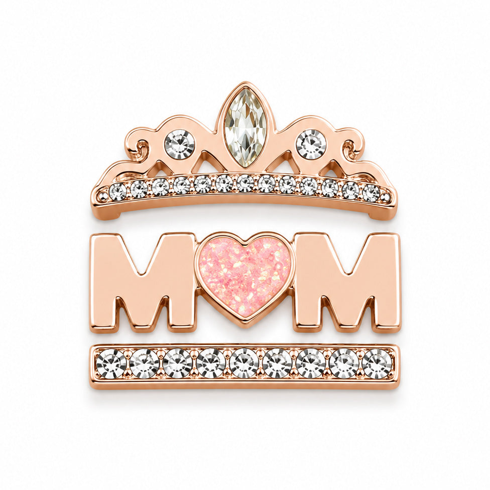 Zoomed-out view of a rose gold-toned decorative accessory set featuring a crystal tiara, pink heart, MOM lettering, and crystal-studded bar details on a white background.