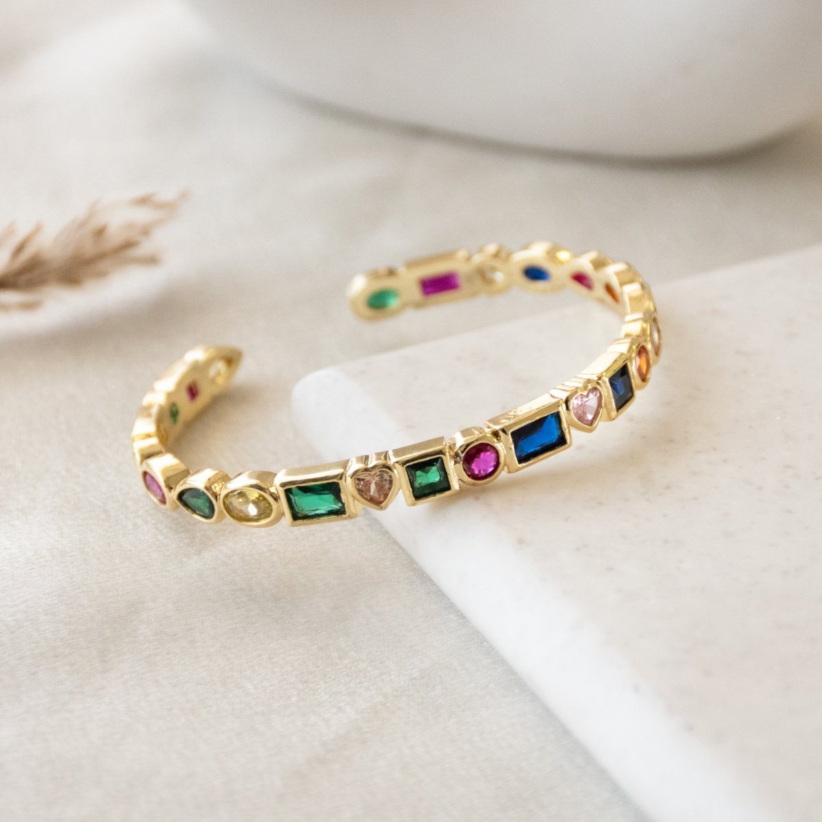 Stylish multi-colored cuff bangle with heart, pearl, and geometric charm detailing and an adjustable anti-tarnish finish, perfect for playful stacking, everyday glam, and trendy statement styling.
