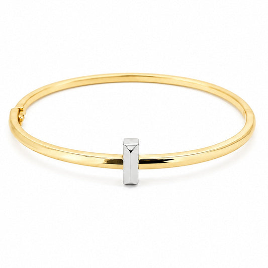 Anti-tarnish two-tone gold bangle bracelet featuring a slim, polished gold band accented with a central vertical silver faceted bar and a side hinge closure.