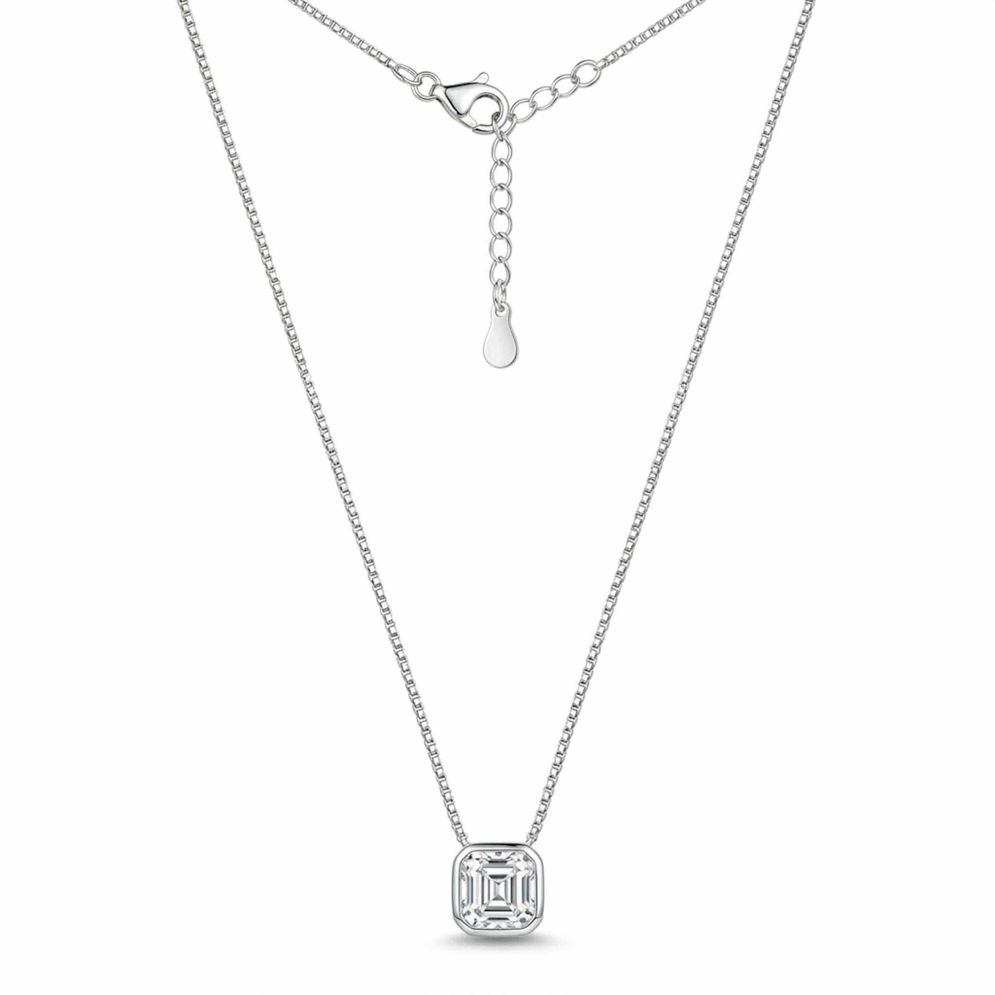 Silver geometric solitaire pendant necklace featuring a square-cut crystal in a bezel setting on a delicate chain, displayed on a white background.