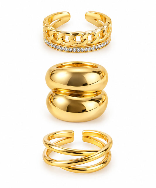 Three gold statement rings featuring a chunky chain pavé open ring, a bold double-dome ring, and a modern crisscross open ring on a clean white background.