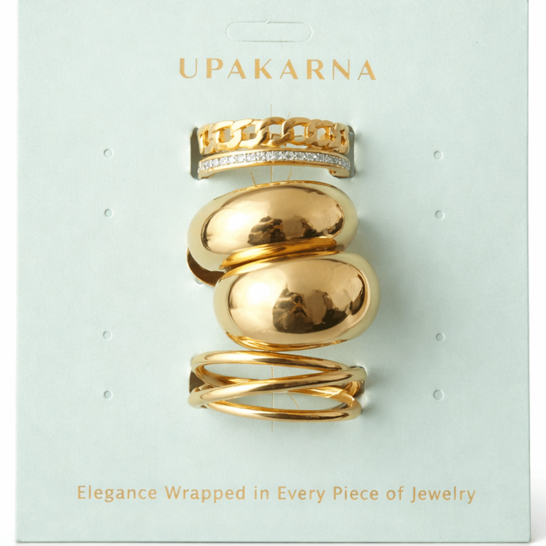 A three-piece gold ring stack featuring a criss-cross entwine band, a structured interlink design, and a bold fluid spiral statement ring.