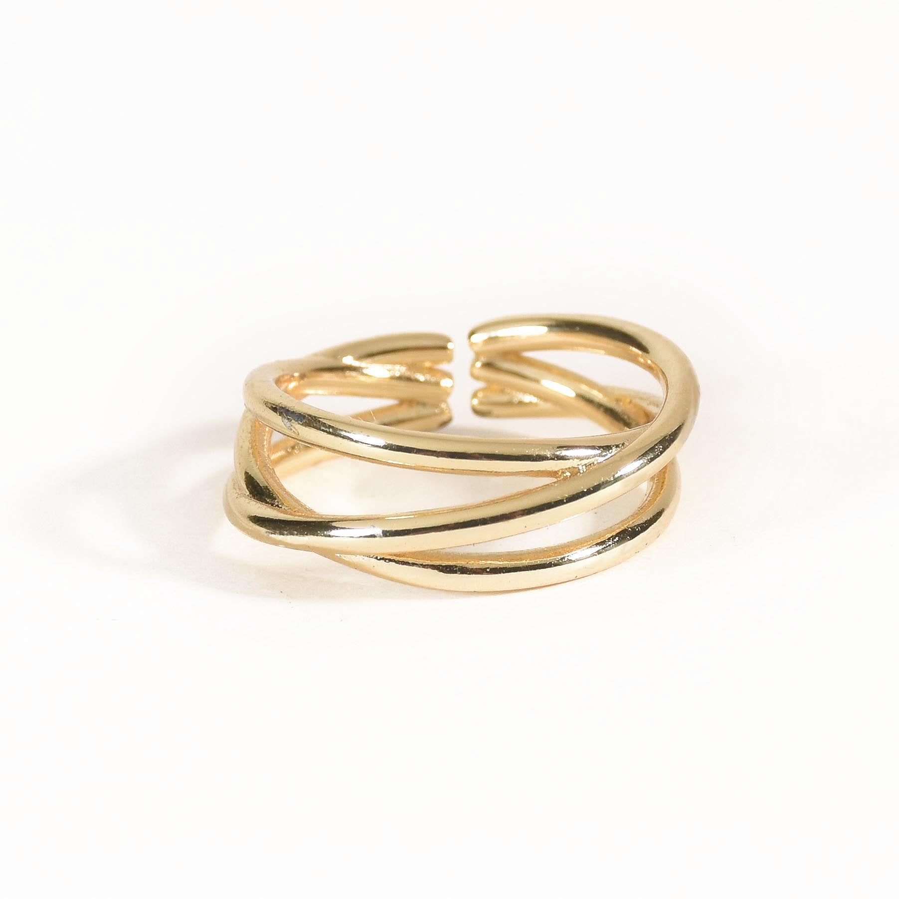 A three-piece gold ring stack featuring a criss-cross entwine band, a structured interlink design, and a bold fluid spiral statement ring.