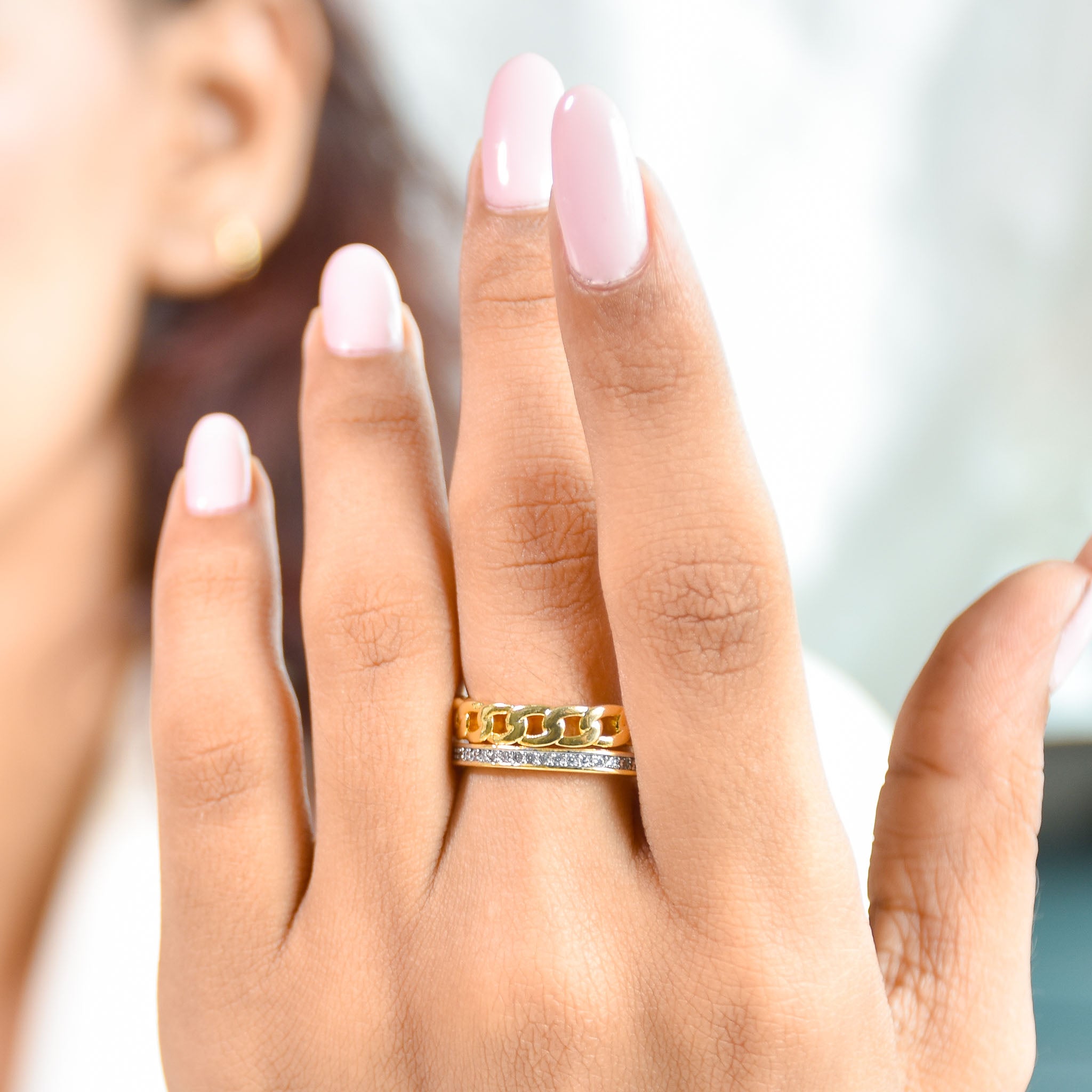 A three-piece gold ring stack featuring a criss-cross entwine band, a structured interlink design, and a bold fluid spiral statement ring.