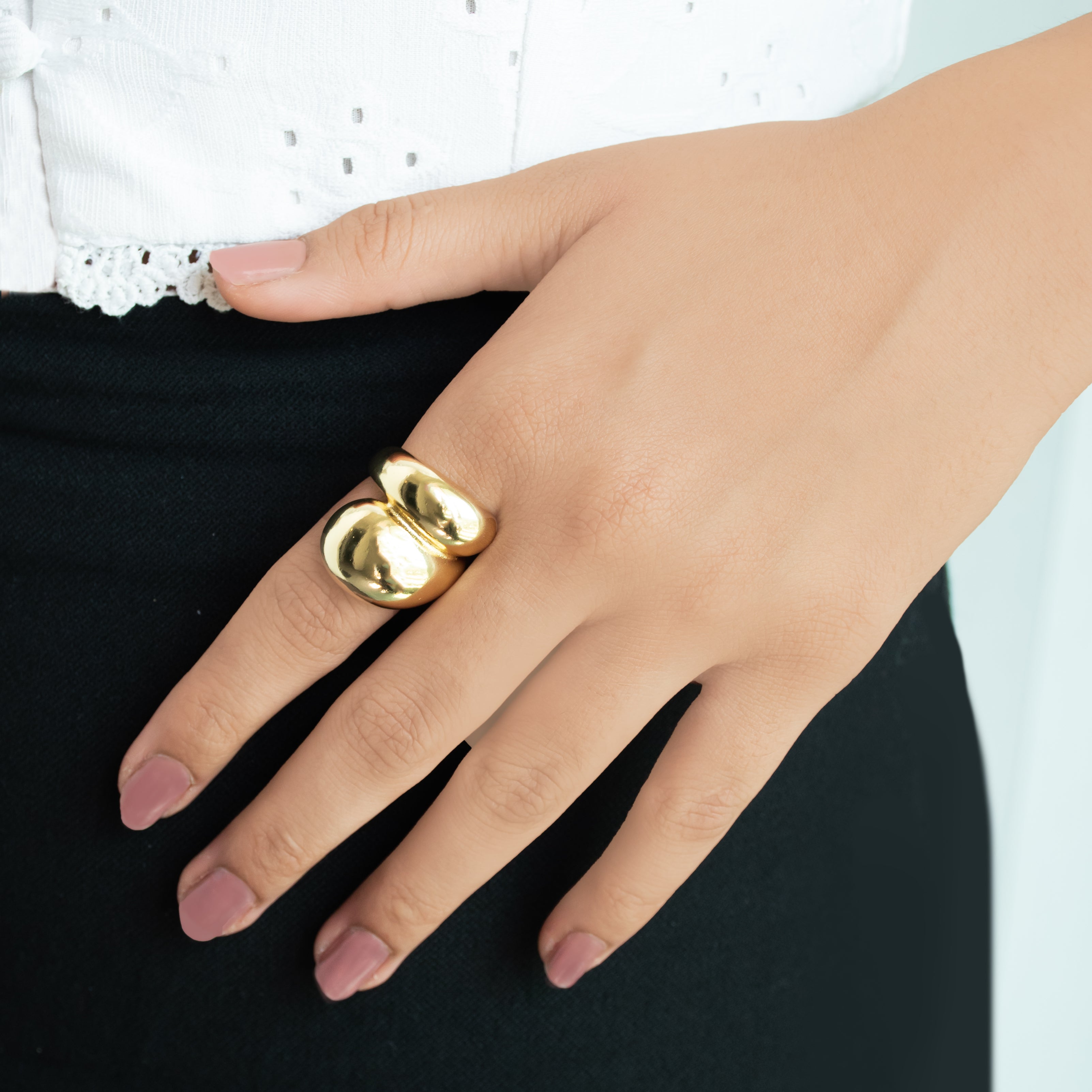 A three-piece gold ring stack featuring a criss-cross entwine band, a structured interlink design, and a bold fluid spiral statement ring.