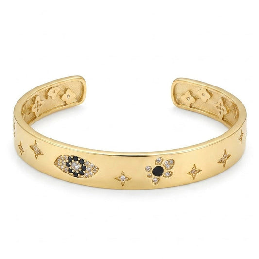 Anti-tarnish yellow gold wide open cuff bracelet featuring inlaid celestial starbursts, a pavé black and clear cubic zirconia evil eye, and a flower motif on a smooth flat band.