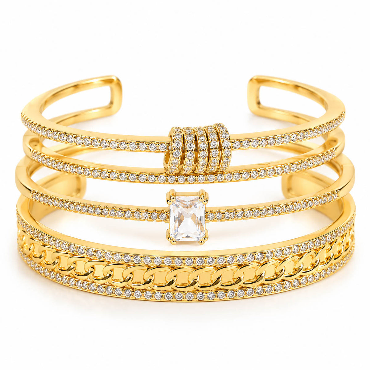 Three gold anti-tarnish bangles stacked together, featuring sparkling pavé crystal detailing, a bold curb-chain design, and an emerald-cut solitaire centerpiece for a premium layered statement look.