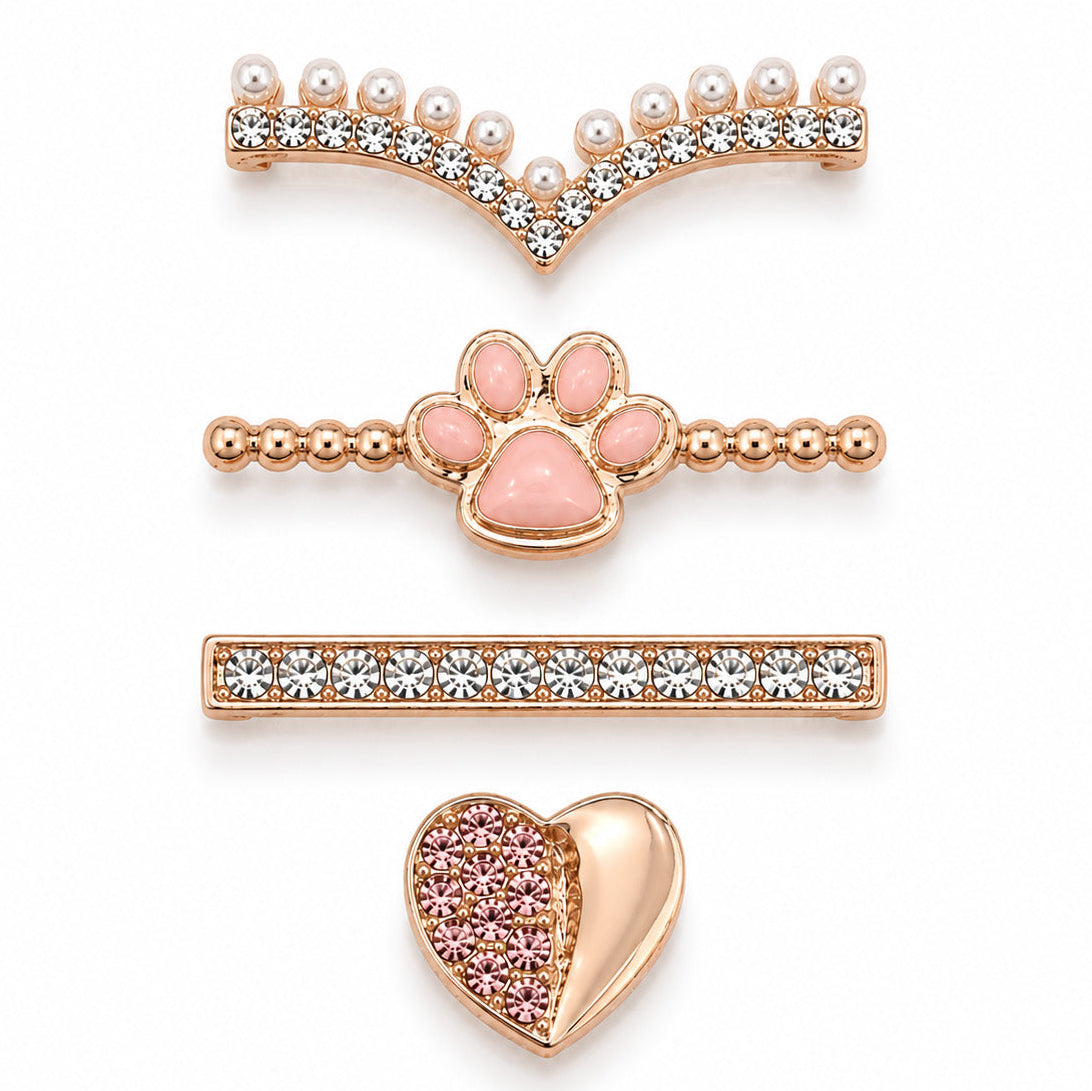 Rose gold-tone watch charms featuring a pearl and crystal V-shaped design, pink paw detail, crystal bar, and pink crystal heart accent, displayed on a white background.
