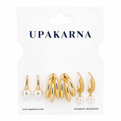 Upakarna gold-tone earring stack featuring pearl stud earrings, layered gold hoop earrings, and textured pearl drop hoop earrings displayed on a branded white jewellery card.