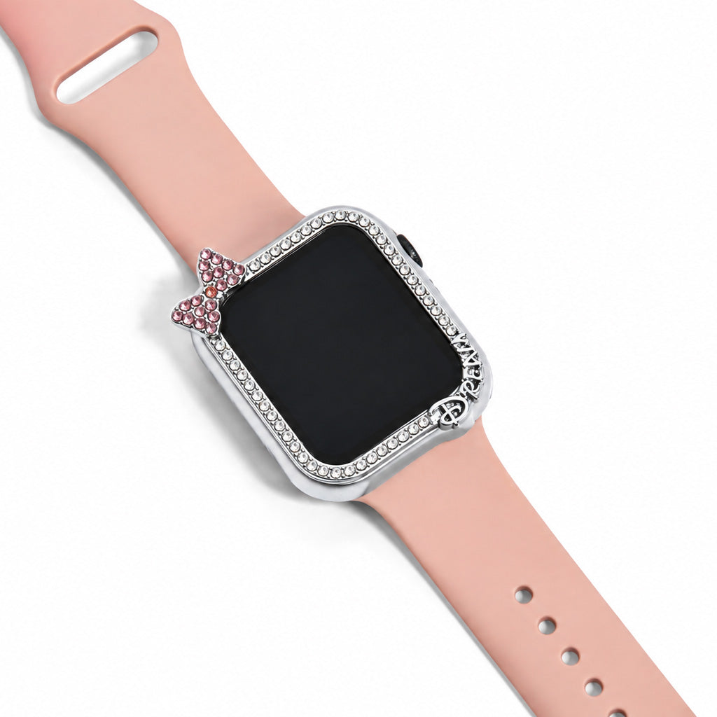 Close-up view of a peach smartwatch strap with a silver crystal-studded watch case, pink bow charm and decorative lettering on a white background.
