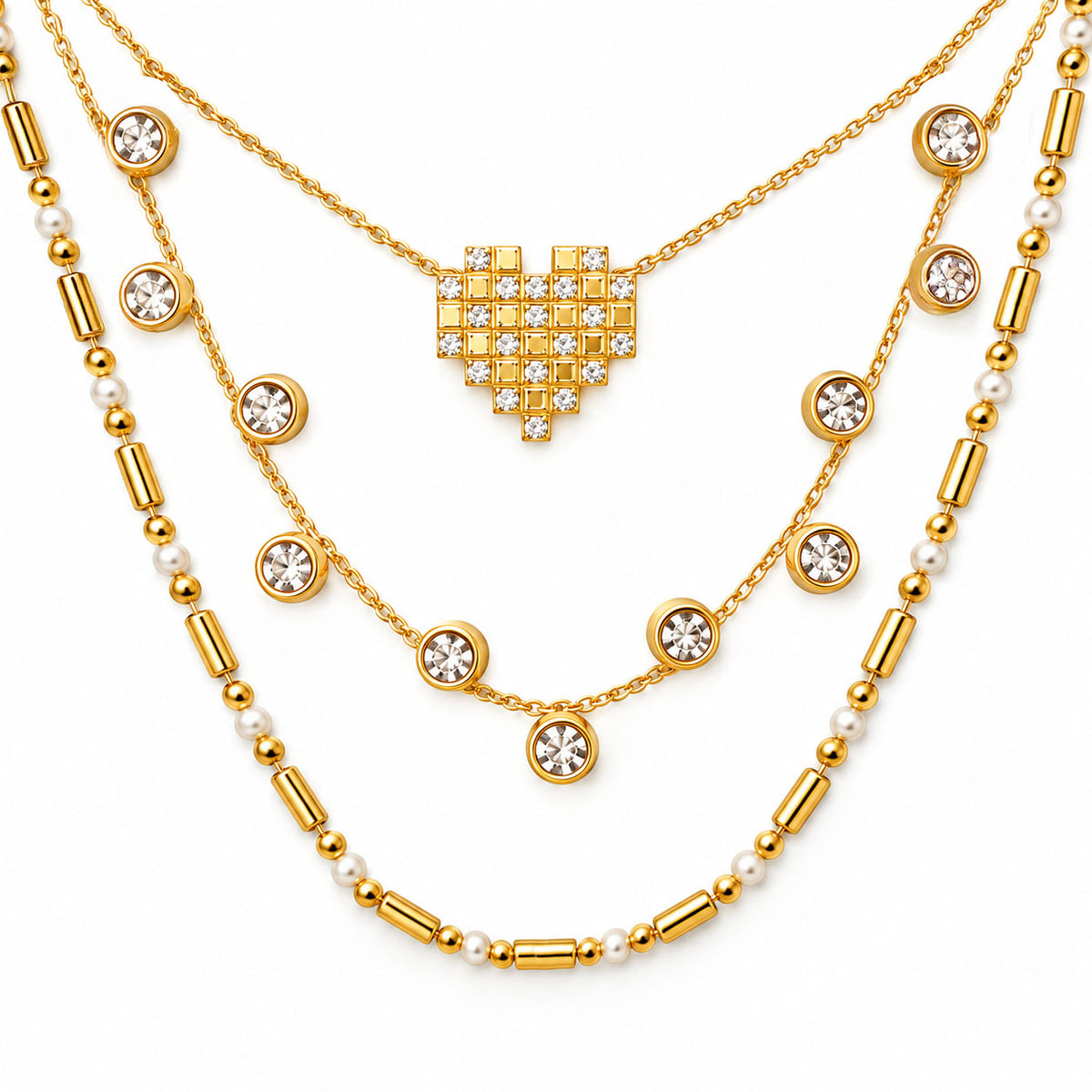 Upakarna gold layered necklace set featuring a crystal pixel heart pendant, bezel-set crystal station necklace, and pearl-bead chain on a clean white background.