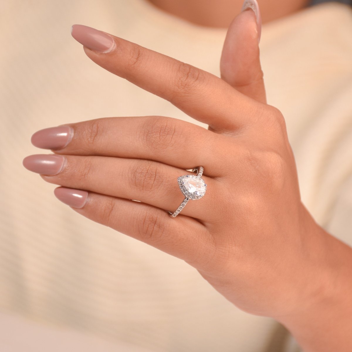 Elegant silver pear-cut halo ring with radiant sparkle and anti-tarnish finish. perfect for engagements, anniversaries, birthdays, and special gifting.
