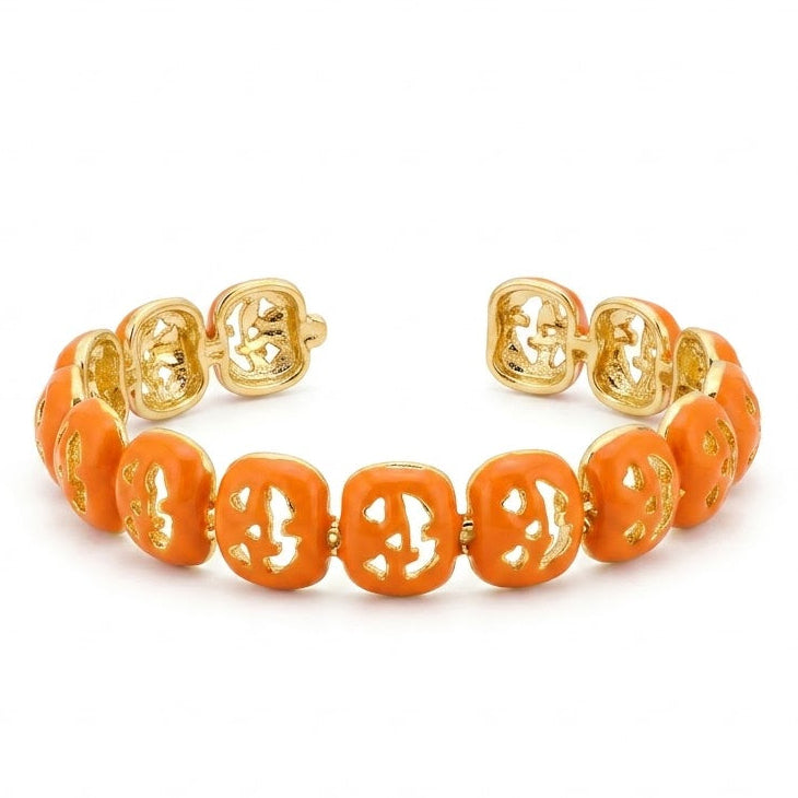 Anti-tarnish yellow gold open cuff bracelet featuring a repeating linked pattern coated in vibrant glossy orange enamel with abstract geometric openwork cutouts.