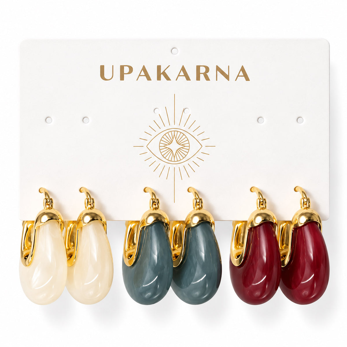 Upakarna earring display card featuring three pairs of glossy resin hoop earrings in ivory, slate blue, and burgundy on a clean white background.