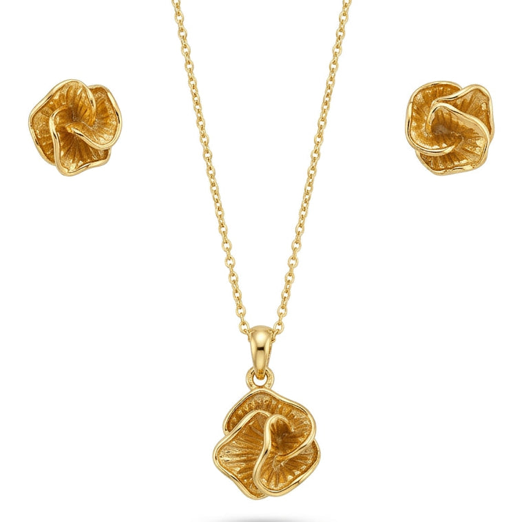 A gold-tone jewelry set featuring a delicate chain necklace with a textured, abstract floral-shaped pendant and matching stud earrings. The design has a sculpted, petal-like form with a hammered finish, giving it a modern, artistic look, displayed on a clean white background.