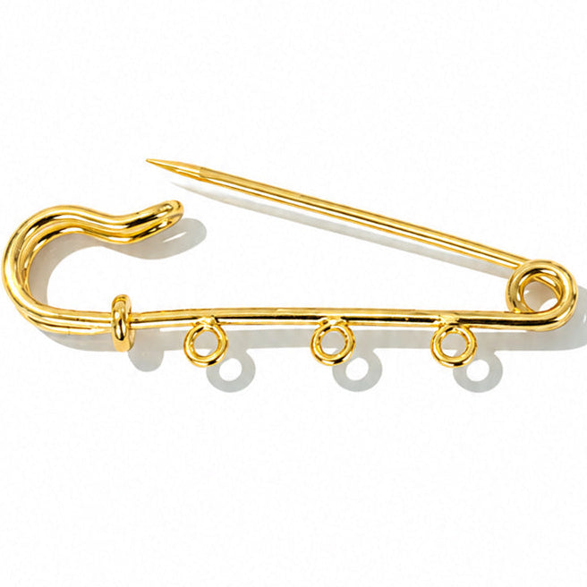 Gold-tone safety pin charm brooch with three small attachment rings along the lower bar, displayed on a clean white background with soft shadows.