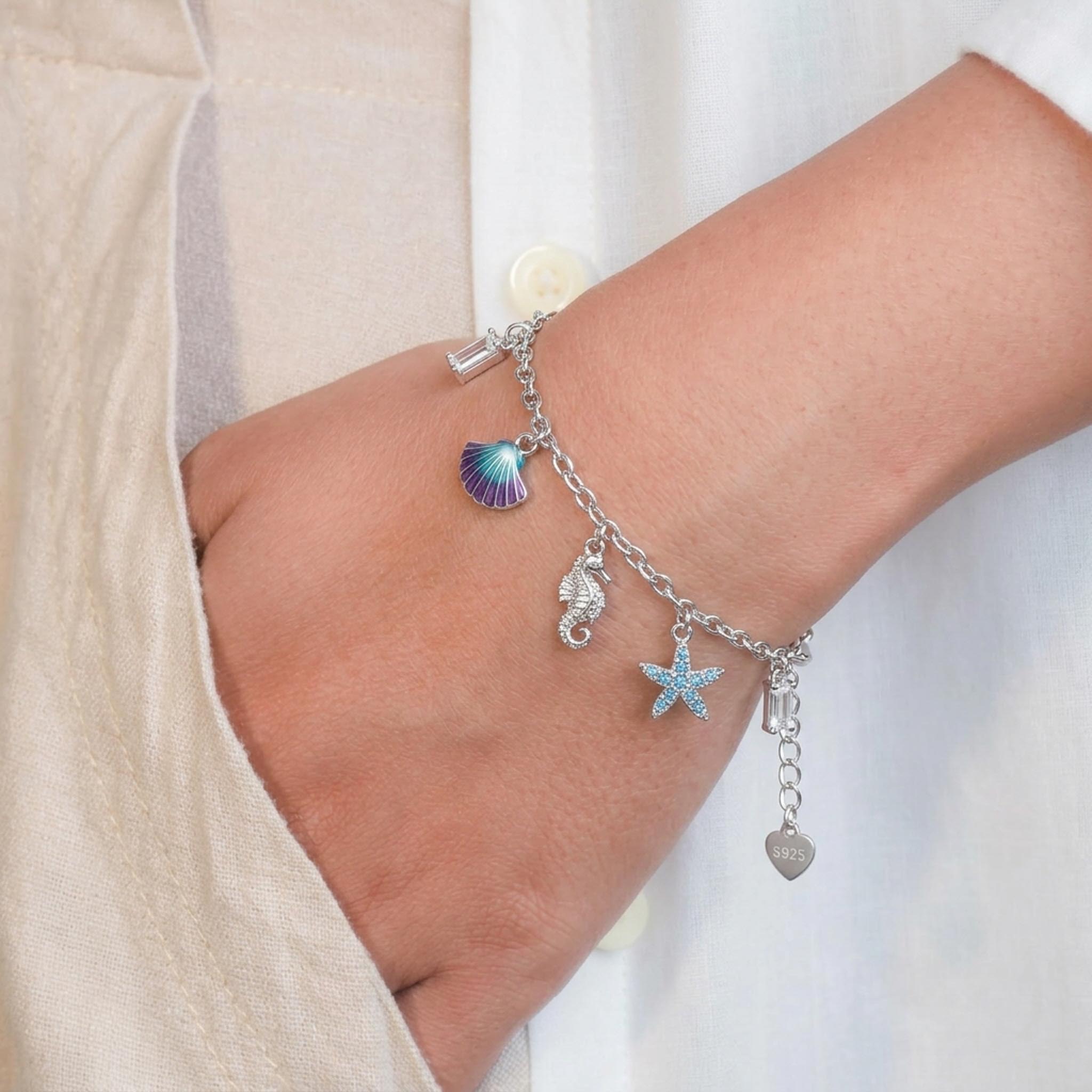 Seascape Charm 925 Sterling Silver Bracelet featuring a polished sterling silver chain adorned with ocean-inspired charms, including a colorful seashell, seahorse, starfish, and bar accents