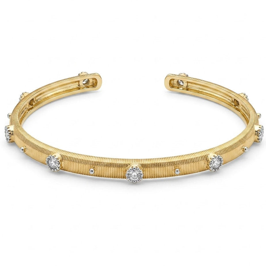 Anti-tarnish yellow gold open cuff bracelet featuring a fine vertically ribbed texture, studded with round clear cubic zirconia halo stations and silver bead accents along the band. on a white background .