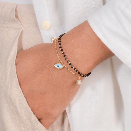 Shimmering evil eye mangalsutra bracelet with crystal detailing and an anti-tarnish finish, perfect for everyday wear and meaningful styling.
