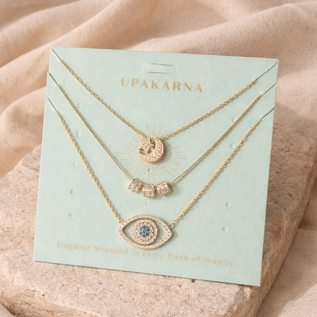 Sparkle Suite Necklace Stack with Crescent Moon & Star, Triple Barrel, and Oceanic Evil Eye layered gold necklaces with crystal detailing