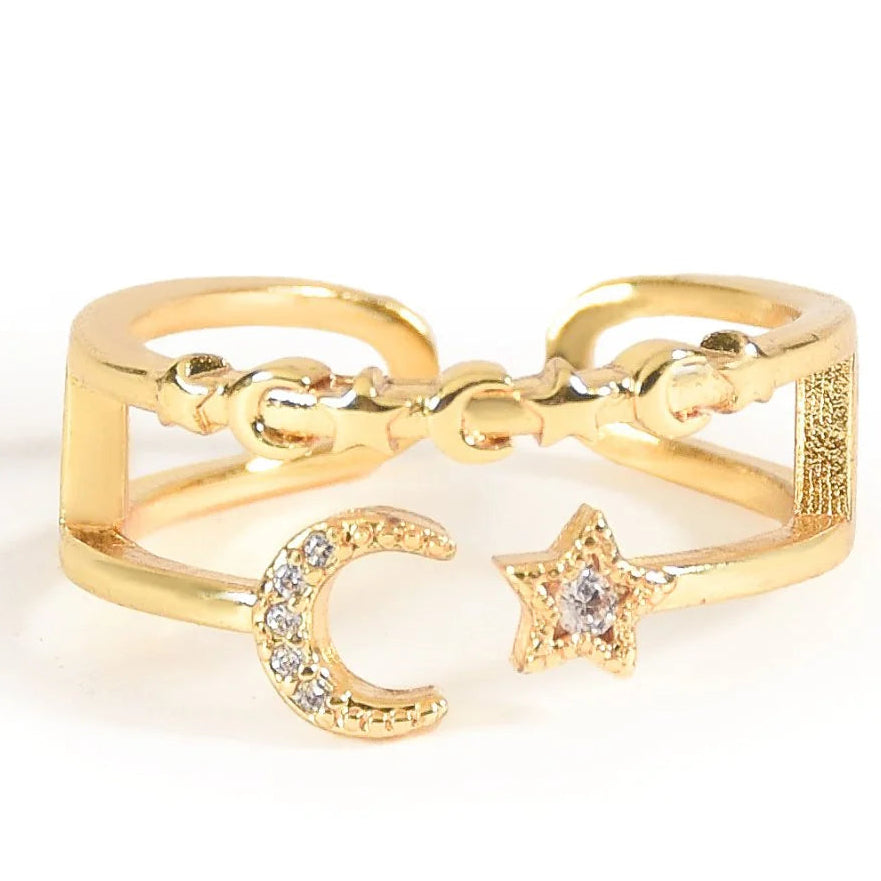 Gold-toned openable bangle featuring a crescent moon and star design, with sparkling crystal detailing and a textured geometric band, photographed on a clean white background.