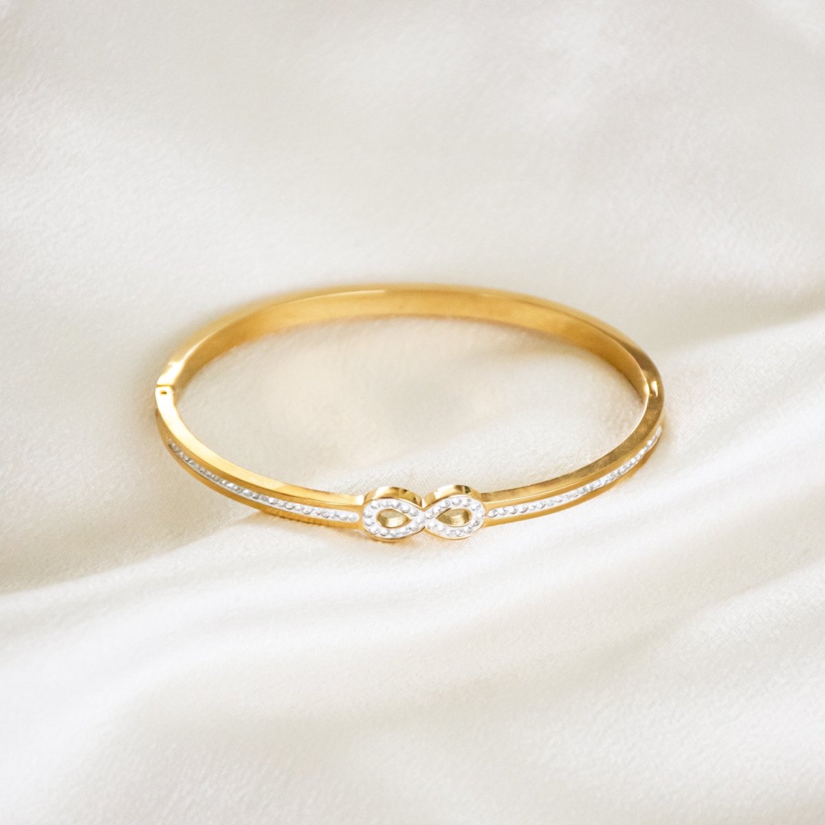 Elegant infinity bangle with sparkling stone detailing and an anti-tarnish finish, available in golden and rosegold, perfect for everyday elegance, gifting, and effortless styling.
