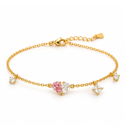 A delicate gold chain anklet featuring a central pink heart-shaped gemstone flanked by clear cubic zirconia stones, with three small star charms, set against a plain white background.