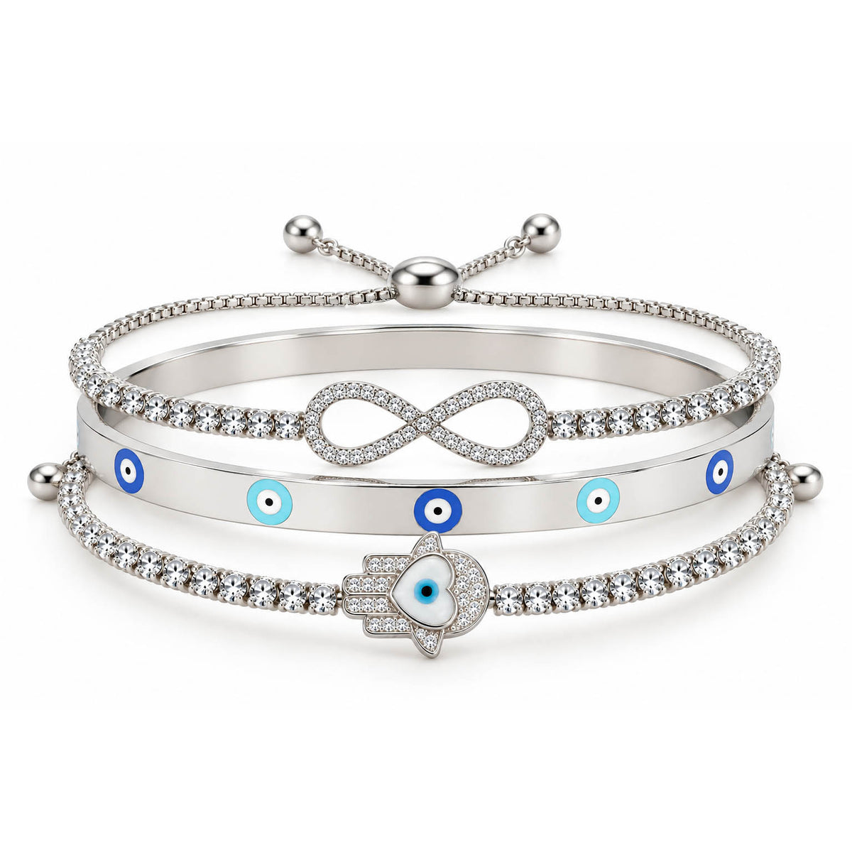 A product photo of a stacked set of silver-tone bracelets featuring an adjustable crystal band with an infinity symbol, a solid bangle with blue-and-white evil eye motifs, and a crystal tennis bracelet centered with a Hamsa hand charm containing a heart-shaped evil eye.