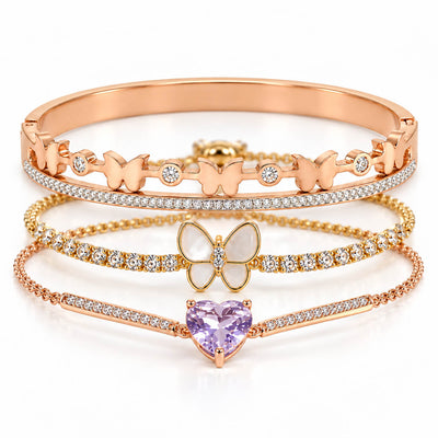 A studio shot of a curated luxury rose gold bracelet stack showcasing three distinct pieces: an upper hinged bangle adorned with small butterflies and crystal stones, a middle crystal-paved chain featuring a central white mother-of-pearl butterfly pendant, and a lower thin link chain centered with a faceted pastel purple heart-shaped crystal.