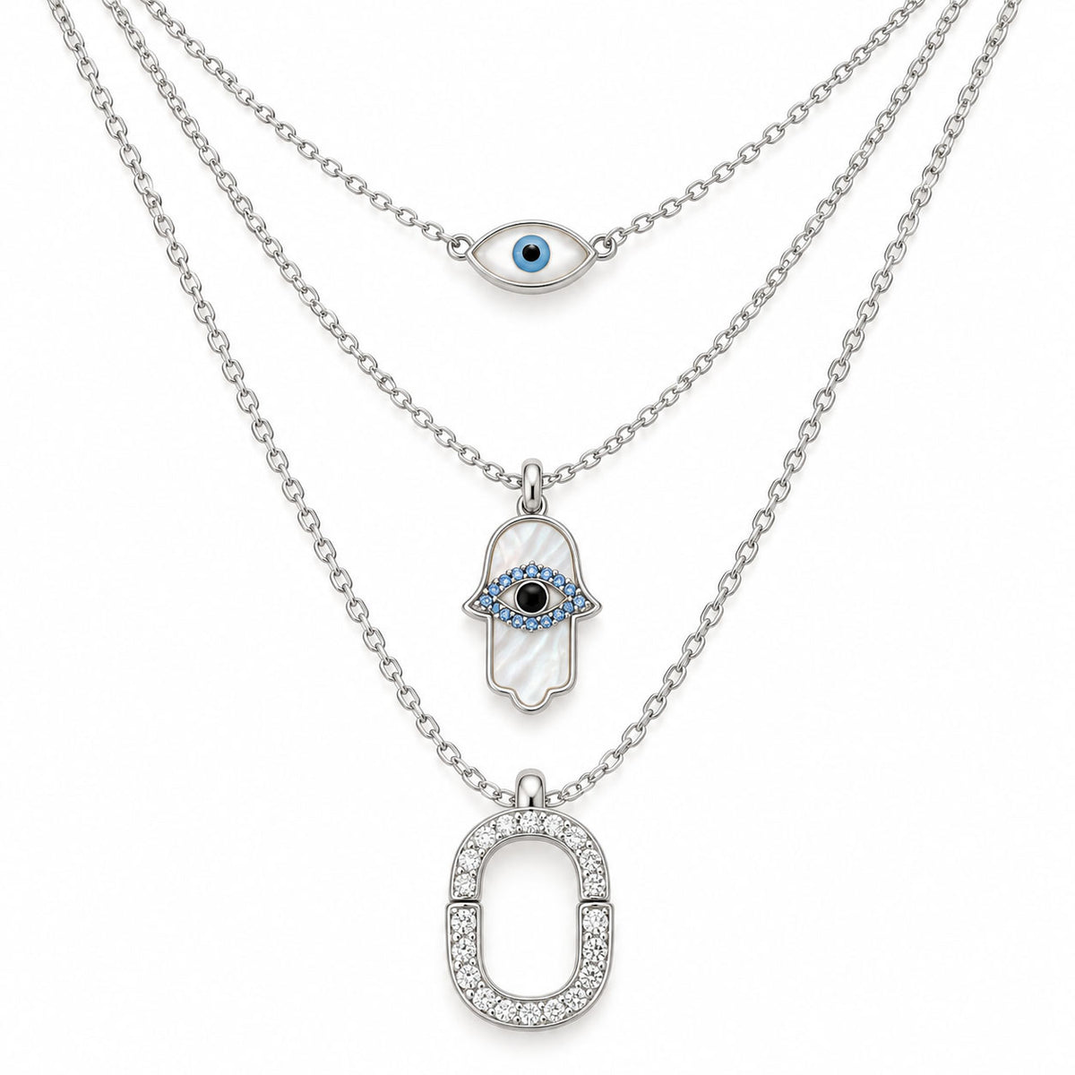 Upakarna silver layered necklace set featuring an evil eye chain, Hamsa evil eye pendant, and crystal pavé link pendant on a clean white background.