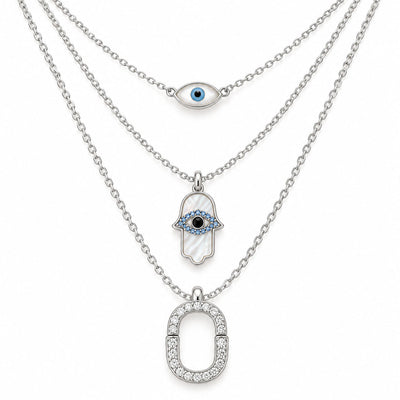 Upakarna silver layered necklace set featuring an evil eye chain, Hamsa evil eye pendant, and crystal pavé link pendant on a clean white background.