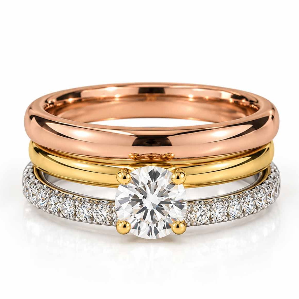 Mixed rose gold, gold and silver ring stack featuring a large round clear center stone and crystal-studded band.