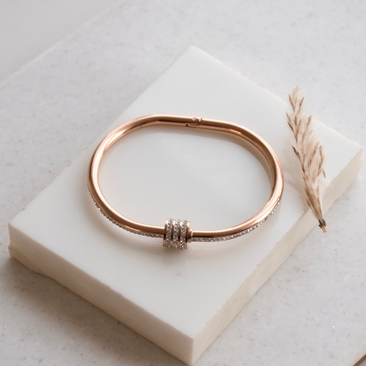 Elegant rosegold twisted sparkle bangle with shimmering stone detailing and an anti-tarnish finish, perfect for everyday glam, casual styling, gifting, and chic layered looks.
