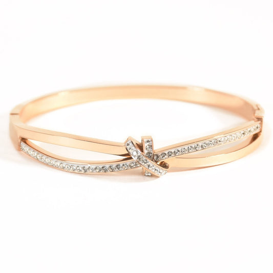 Twisted knot studded bangle with sparkling crystal accents and an anti-tarnish rose gold finish, perfect for everyday wear, elegant styling, and thoughtful gifting.
